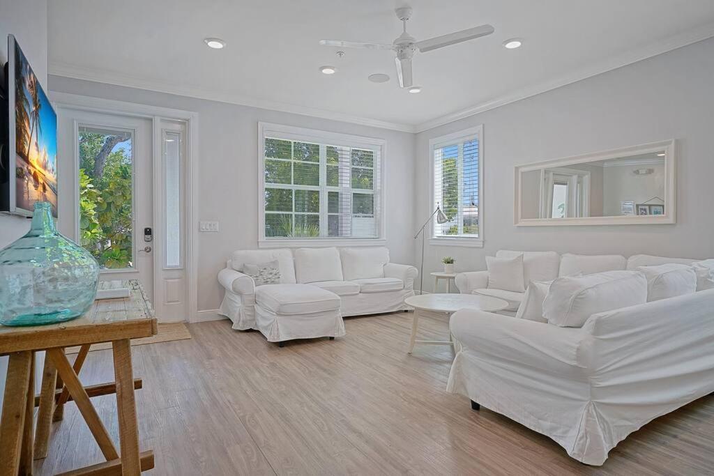 una sala de estar blanca con muebles y ventanas blancos. en 3 Lux Ensuites Walk Boat Island en Islamorada