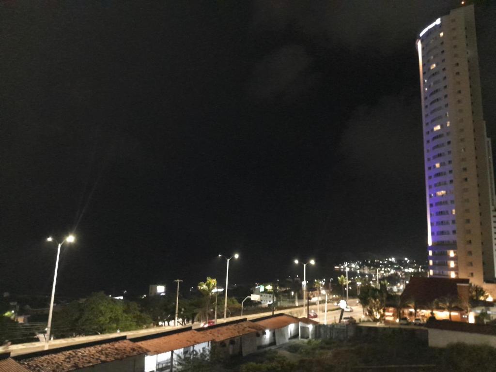 a tall building at night with lights on at Flat Ponta Negra vista para o mar in Natal