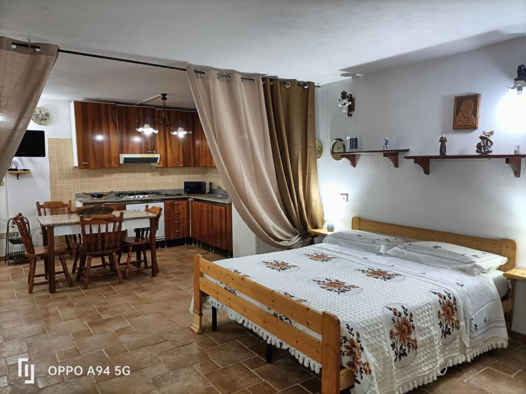 1 dormitorio con cama, mesa y cocina en La Dimora di Angela, en Amendolara