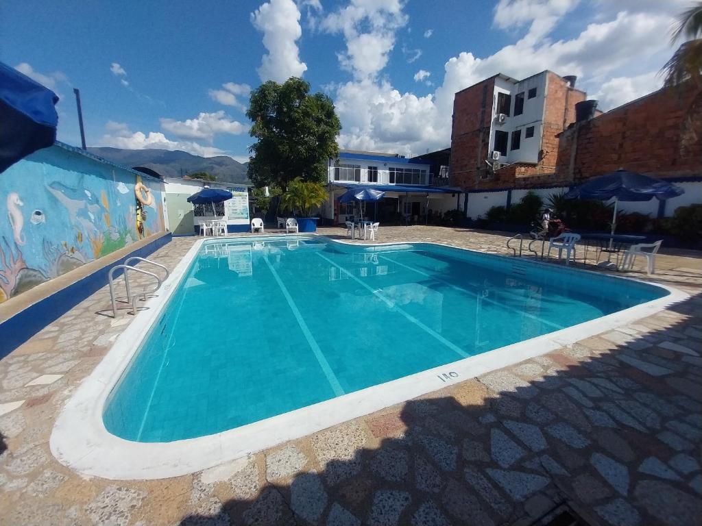 a large swimming pool in a building with a blue at Hotel Guaipa in Melgar