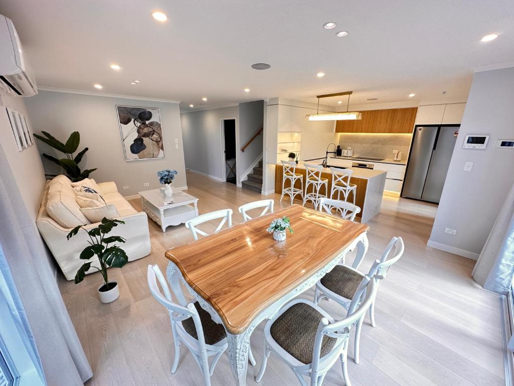 奧克蘭的住宿－123B Forresthill Rd，厨房以及带木桌和椅子的客厅。