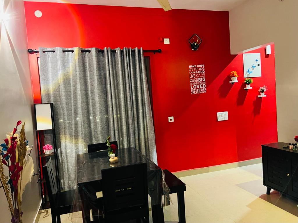 une chambre avec un mur rouge et un rideau dans l'établissement Tani s Homestay, à Bāruipur