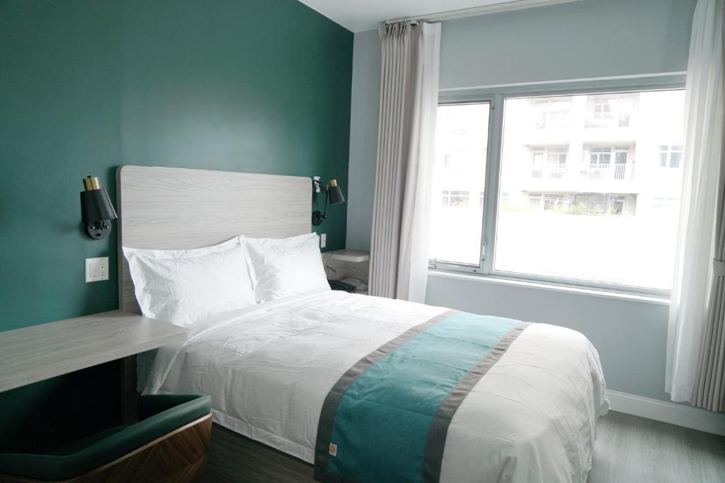 Un dormitorio con una cama grande y una ventana en Starlight Hotel, en Flushing