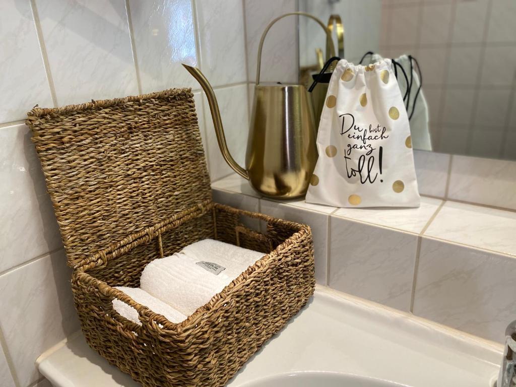 a basket sitting on top of a sink in a bathroom at Eurenerstrasse 179 Tourist Apartments in Trier
