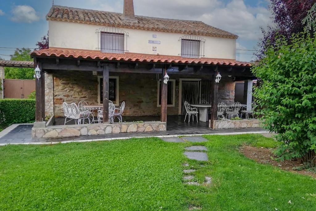 een huis met een veranda met een tafel en stoelen bij Charming Casa Rural El Pedregal 