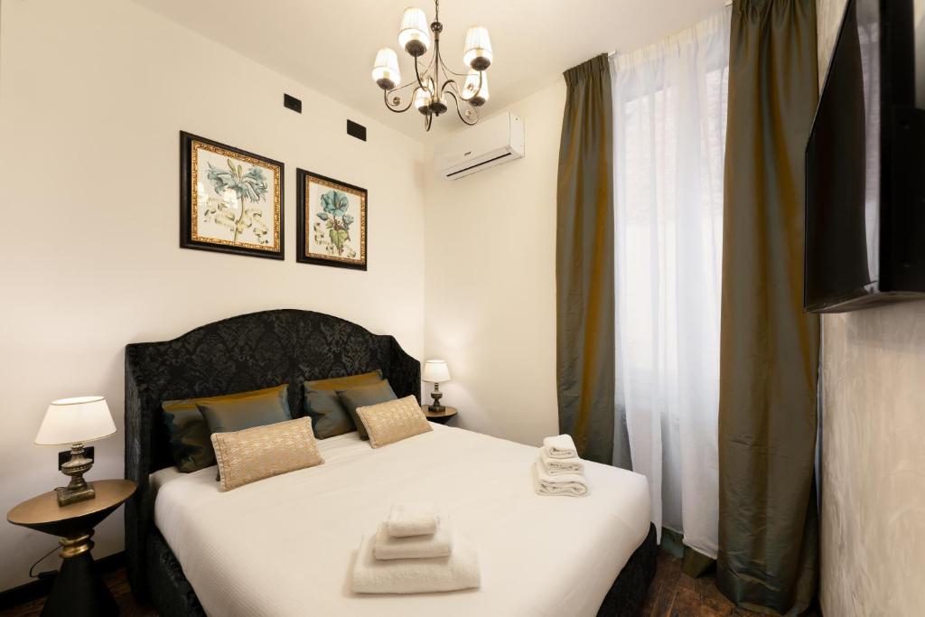 una camera da letto con un letto bianco e una finestra di Pitti Elegant Suite a Firenze