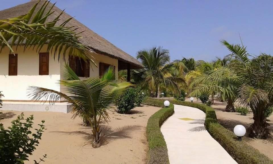 een pad voor een huis met palmbomen bij Campement Nyabinghi in Abémé