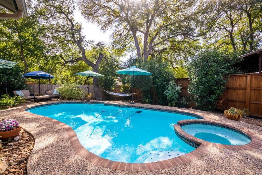 a swimming pool in a backyard with an umbrella at One of San Antonio's Finest in San Antonio