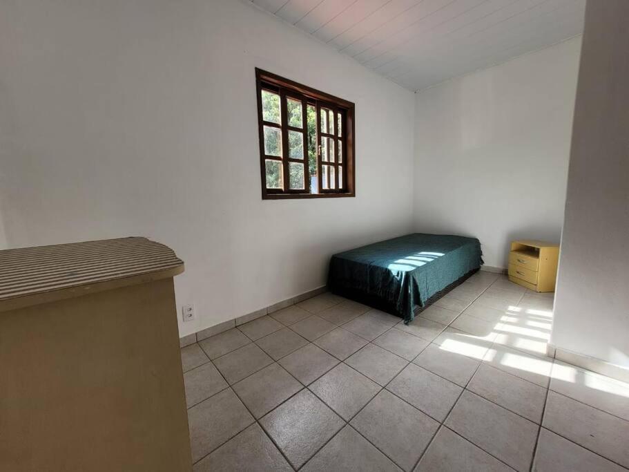 een kamer met een bed in een kamer met een raam bij Sobradinho Morro das Pedras in Florianópolis