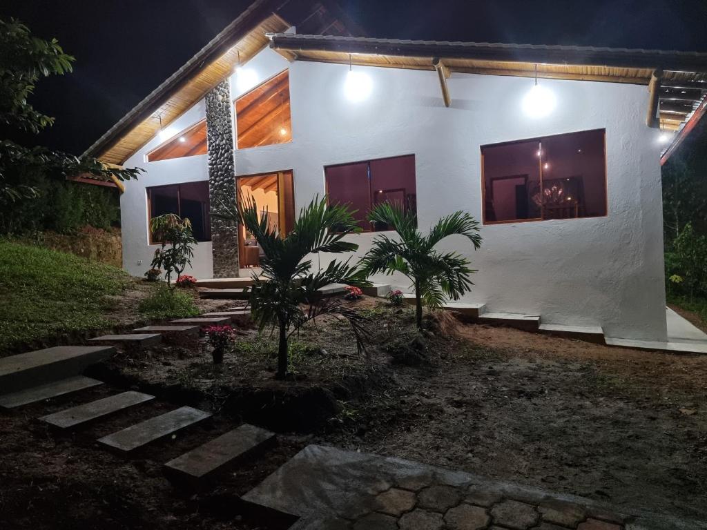 een wit huis 's nachts met lichten aan bij La Marujita villa de campo in Puerto Quito