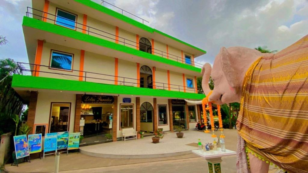 a man eating food in front of a building at Lotus Paradise Resort - SHA PLUS in Koh Tao