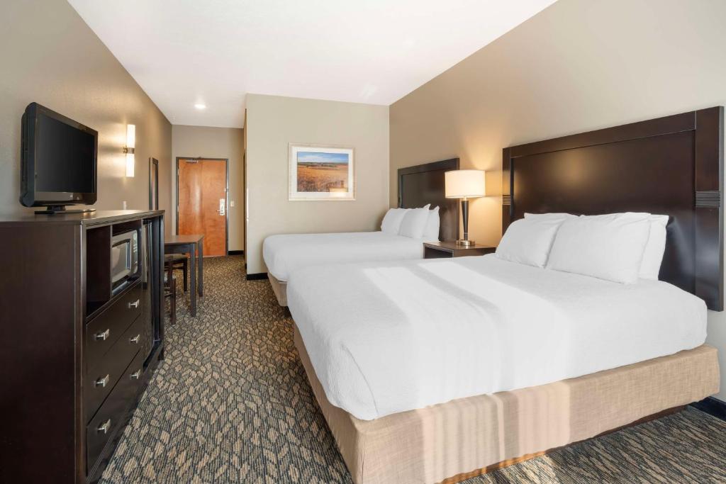 a hotel room with two beds and a flat screen tv at Best Western Wheatland Inn in Colfax