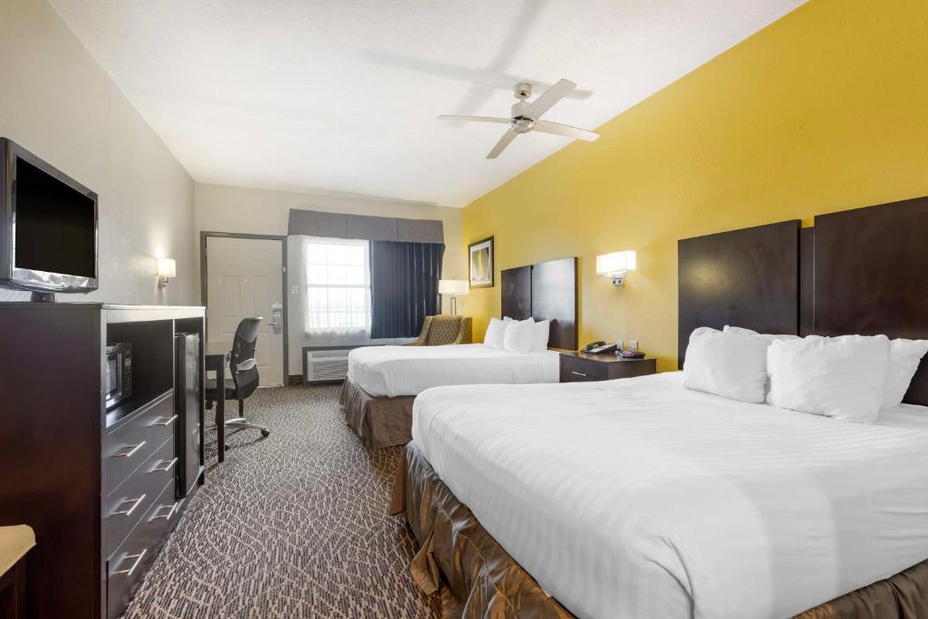 a hotel room with two beds and a flat screen tv at Best Western West Monroe Inn in West Monroe