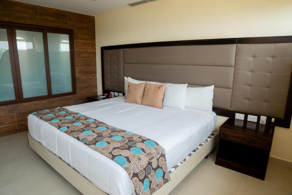 a bedroom with a large bed with a large headboard at Playa Paraíso in Playas