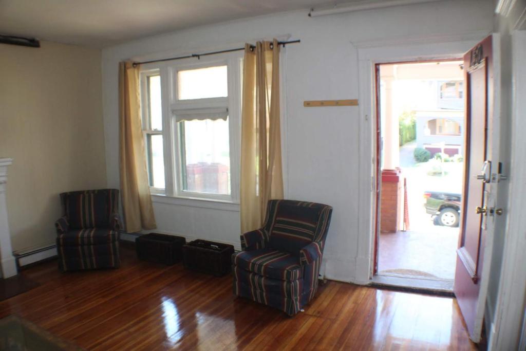 a living room with two chairs and an open door at Historic West End Gem in Hartford