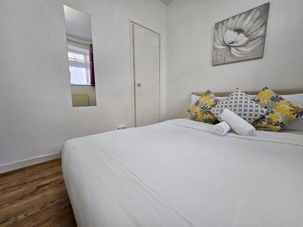 1 dormitorio blanco con 1 cama blanca grande con almohadas en Globe Rooms, en Londres