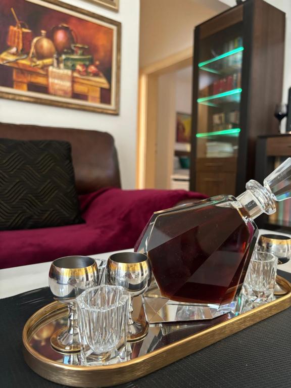 a tray with a bottle of wine and glasses on a table at Stylish King Downtown in Podgorica