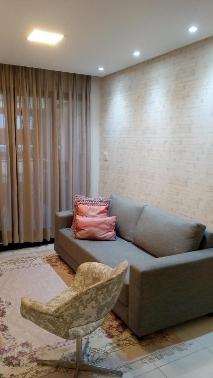 Apartamento Estilo Prime في سلفادور: غرفة معيشة مع أريكة وكرسي