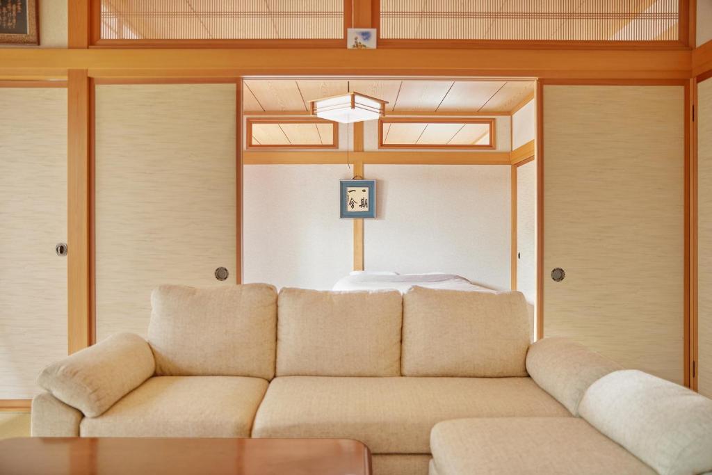 een woonkamer met een bank en een bed bij Guesthouse Ichigo Ichie Nikko in Nikko