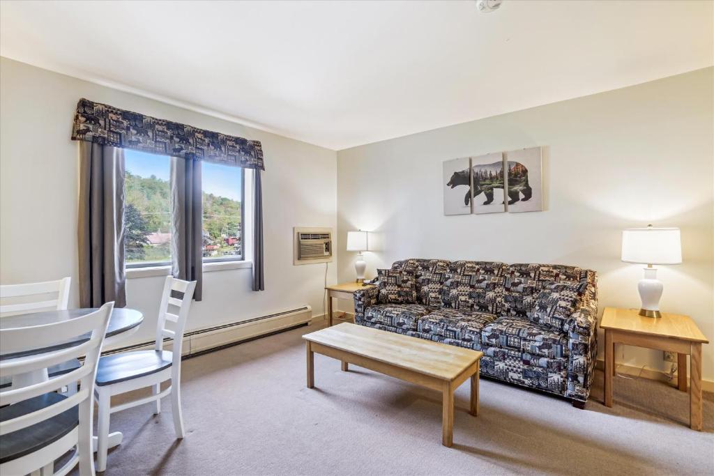 uma sala de estar com um sofá e uma mesa em Cedarbrook Deluxe one bedroom suite with outdoor heated pool 21517 em Killington