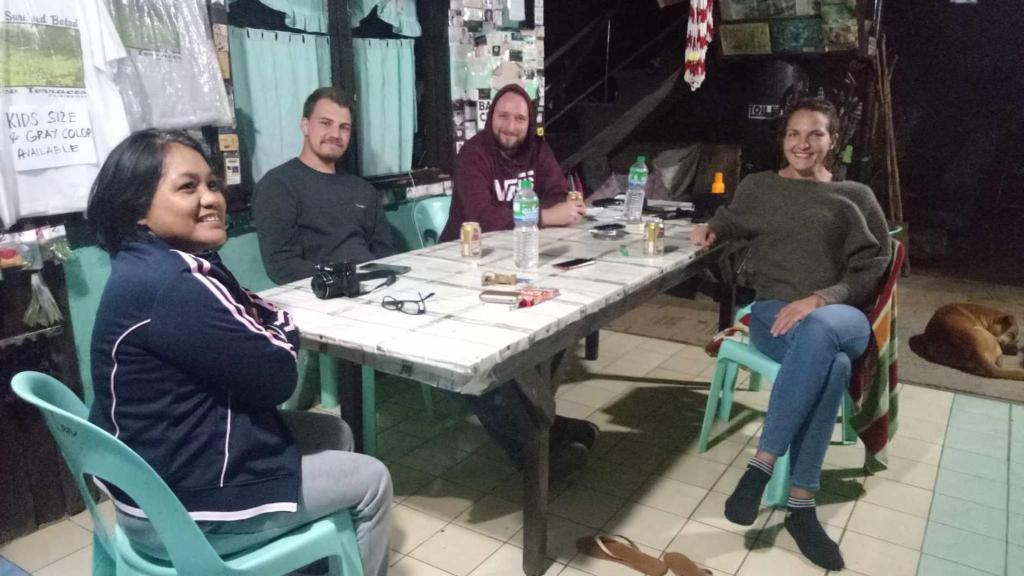 een groep mensen die rond een tafel zitten bij BATAD Rita's Mount View Inn and Restaurant in Banaue