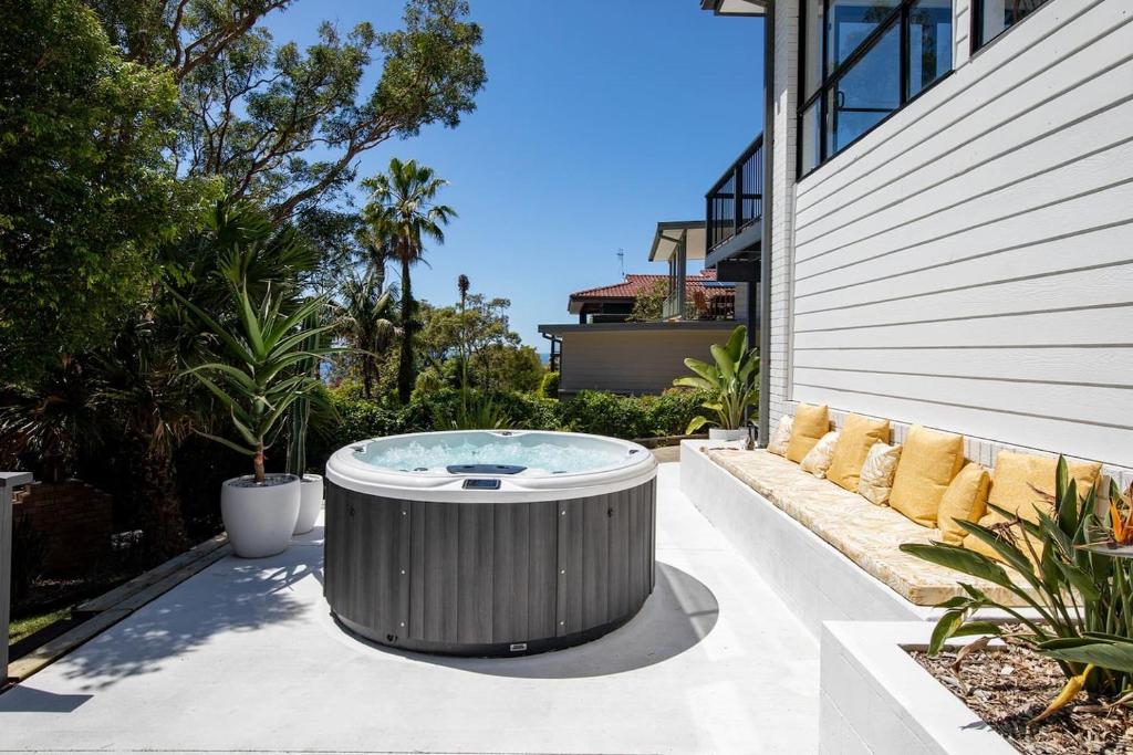 a hot tub sitting on a patio next to a building at Aqua Vistas - Recharge on the Coast in Style in Macmasters Beach