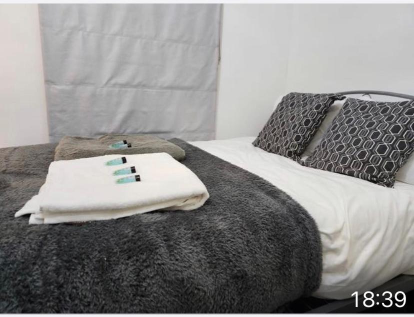 a bed with two towels on top of it at Cozy Guest House in Kent