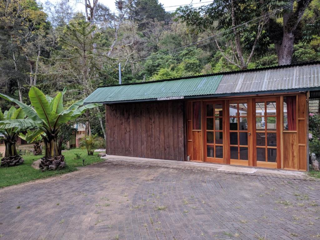 a wooden building with a green roof at Riverside Studio- Hush Valley Lodge in Río Blanco