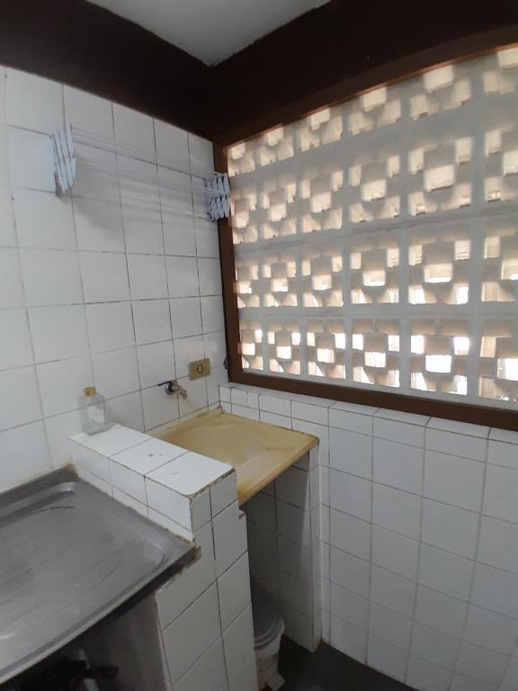 a bathroom with a sink and a window at Chalés Recanto da Praia in Caraguatatuba