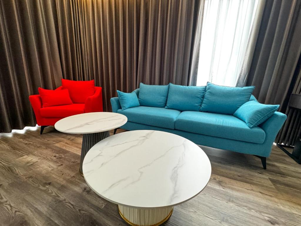 a living room with a blue couch and two red chairs at Venus Royale Hotel in Coron