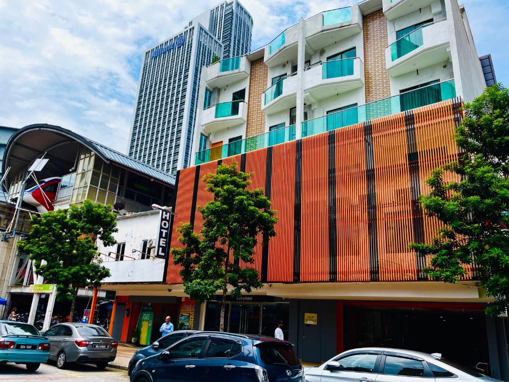 uma rua com carros estacionados em frente a um edifício em Cozy Hotel@ KL Sentral em Kuala Lumpur