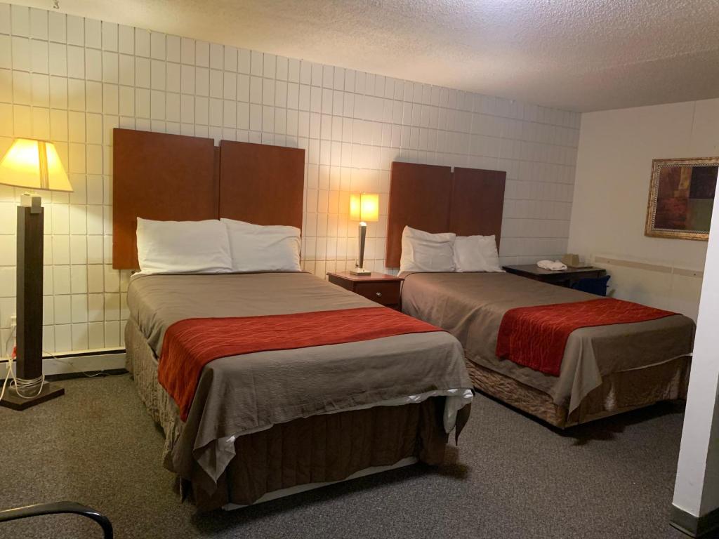 een hotelkamer met 2 bedden en 2 lampen bij Franklin Motel in Assiniboia