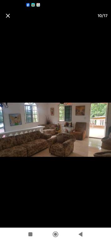 una gran sala de estar con sofás, mesas y ventanas. en Hospedaje Portobelo en Portobelo