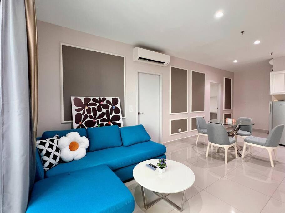 uma sala de estar com um sofá azul e uma mesa em Homely 2BR, Free Carpark @ Direct Link Central Mall, SOGO, Theme Park em Shah Alam