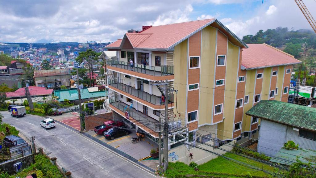 un gran edificio amarillo con techo rojo en una calle en RNJ Hotel, en Baguio