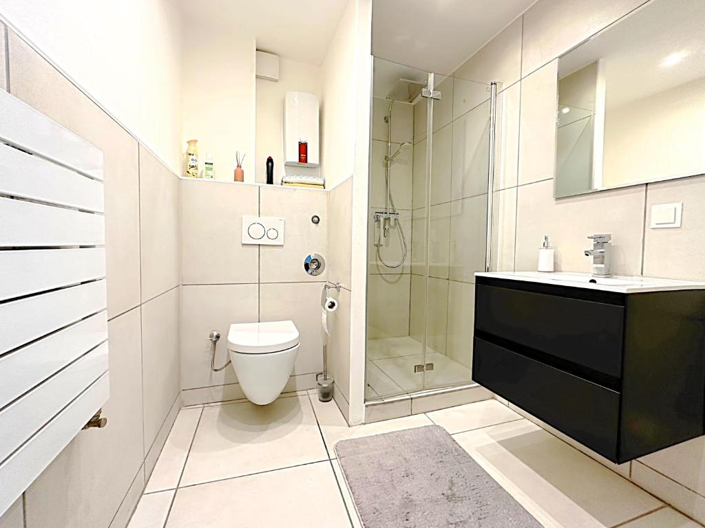 uma casa de banho com um WC, um chuveiro e um lavatório. em HomeZone Seelze em Seelze