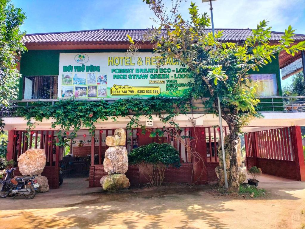 a hotel with a sign in front of a building at FOREST BREATH ECO-LODGE in Tân Phú