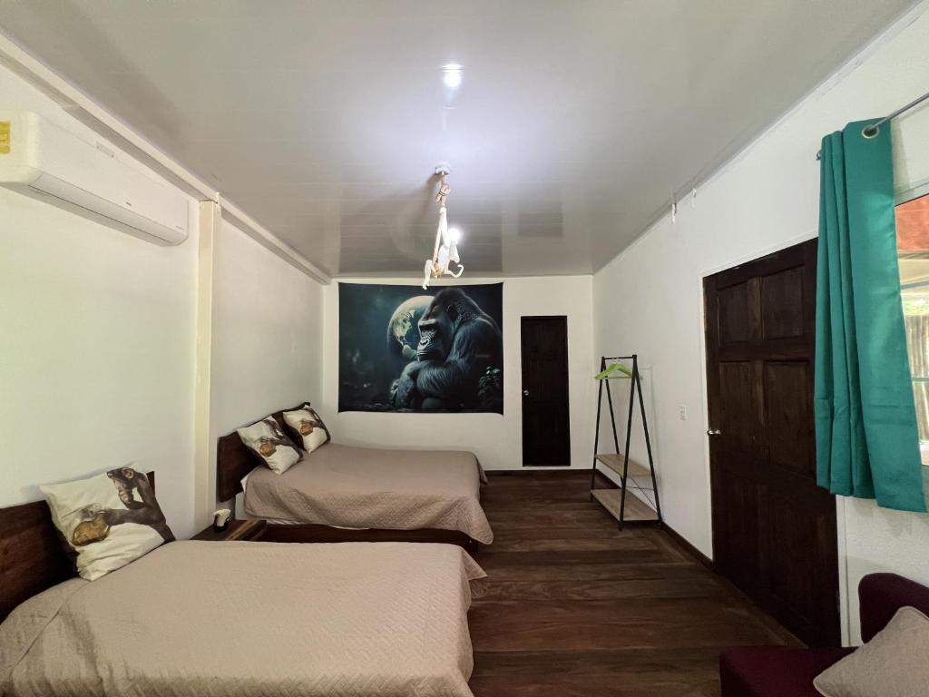 Habitación con 2 camas y una pintura en la pared. en Monkey Lodge Panama en Chilibre