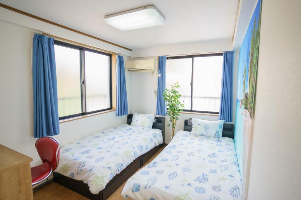 1 dormitorio con 2 camas y 2 ventanas en BURan House, en Tokio