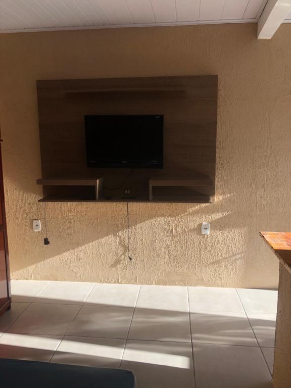 a wall with a flat screen tv on a wall at Pousada Patriarca Silva in Rio Grande