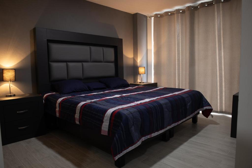 um quarto com uma cama grande e um cobertor listrado em Casa en puebla em El Gallinero