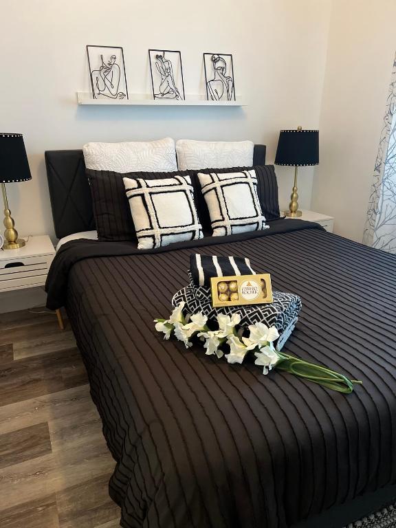 uma cama preta com uma bandeja de flores em Le St-Augustin em Mirabel