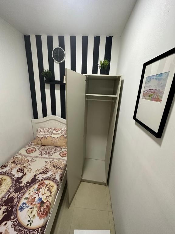 a small room with a bed and a shelf at Solo Partition Room in Al Barsha 1 Near Mashreq Metro in Dubai