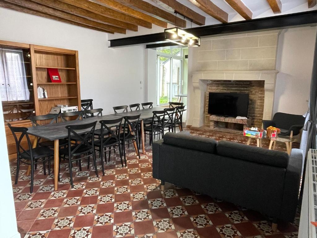a living room with a table and chairs and a fireplace at Maison spacieuse près du Mans et Tours, idéale pour famille, avec terrasse, jardin et parking - FR-1-410-425 in Chahaignes