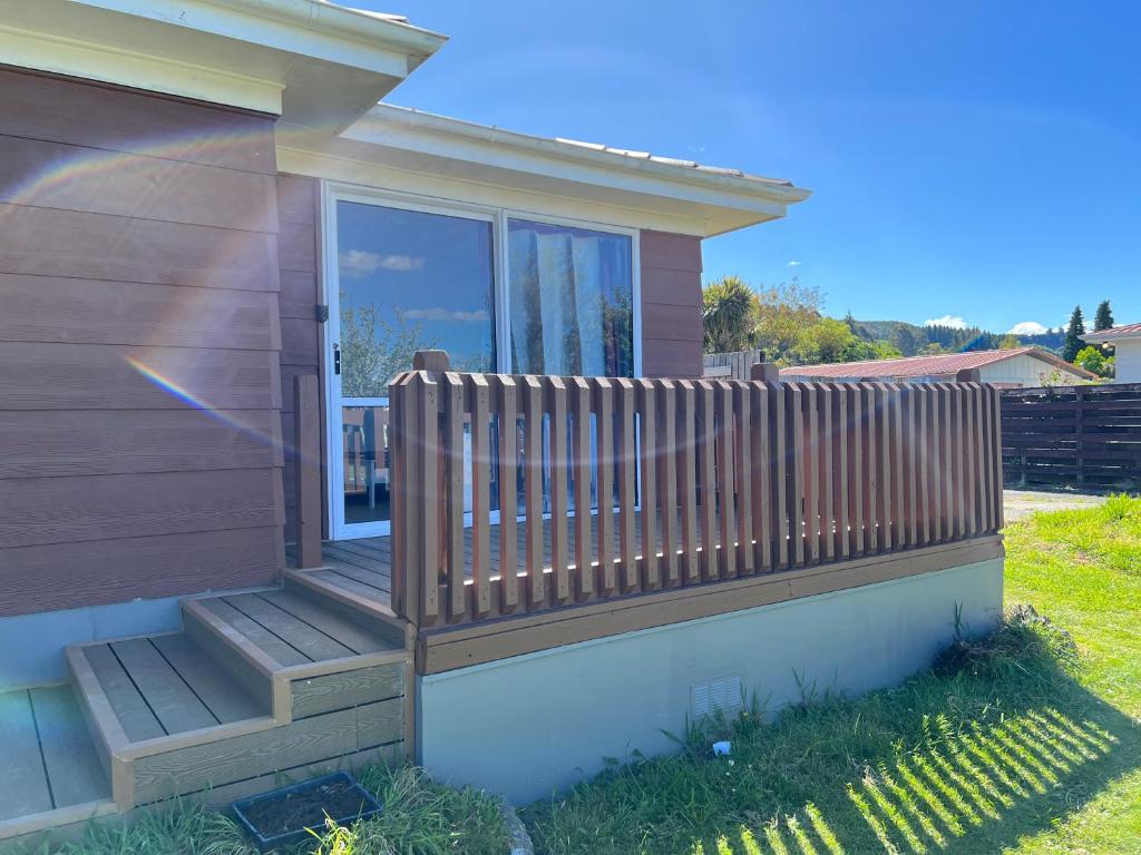 a house with a wooden porch with a fence at Cozy 2 bedrooms Studio 6A Chapman Place, no kitchen in Rotorua