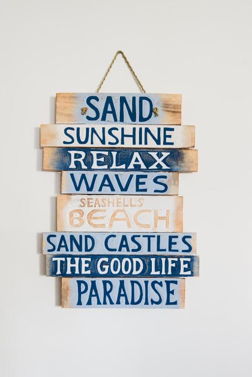 a stack of books with the words sand sunshine relawn waves seashells research at Growder Court 3 - Coolum Beach QLD in Coolum Beach