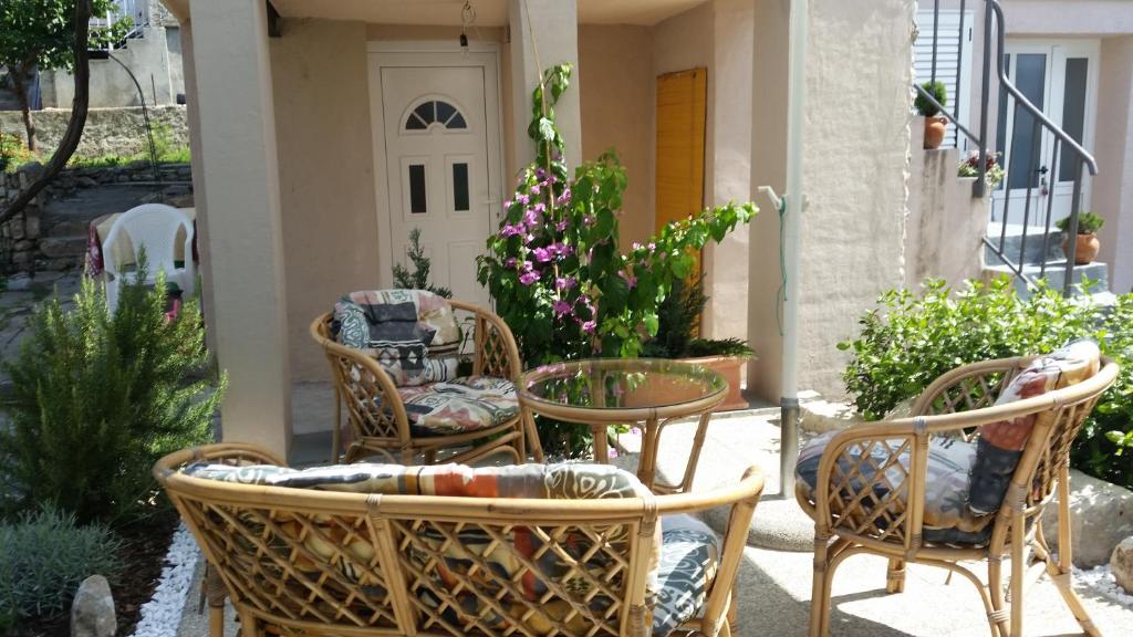 Apartments Mali Raj في Vranjic: مجموعة من الكراسي والطاولات على الفناء