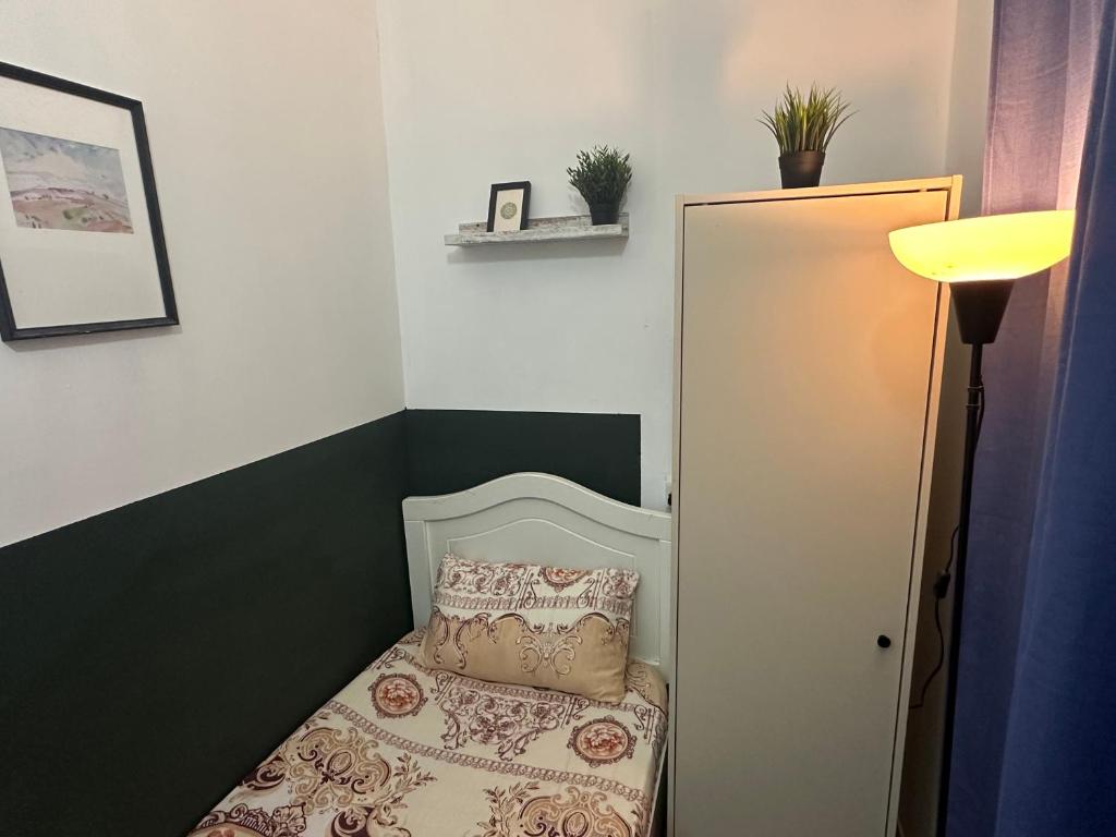 a small bedroom with a bed and a lamp at Private Partition Room Near Mashreq Metro in Dubai