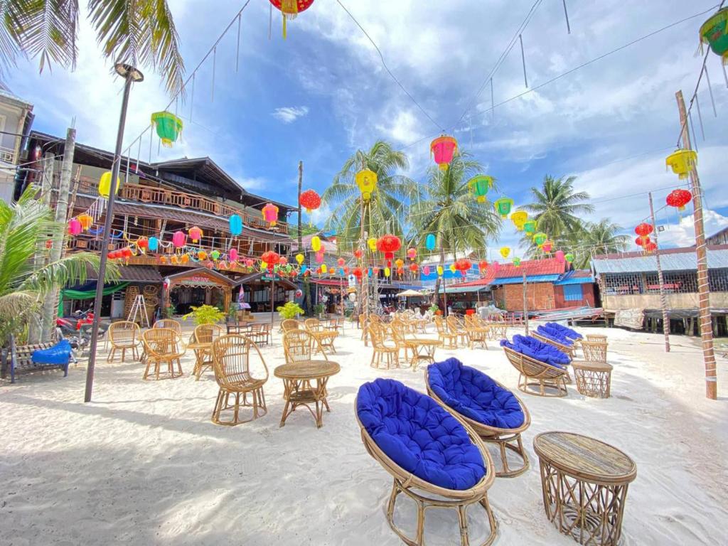 un grupo de sillas y mesas en una playa en Green Ocean Lodge, en Koh Rong