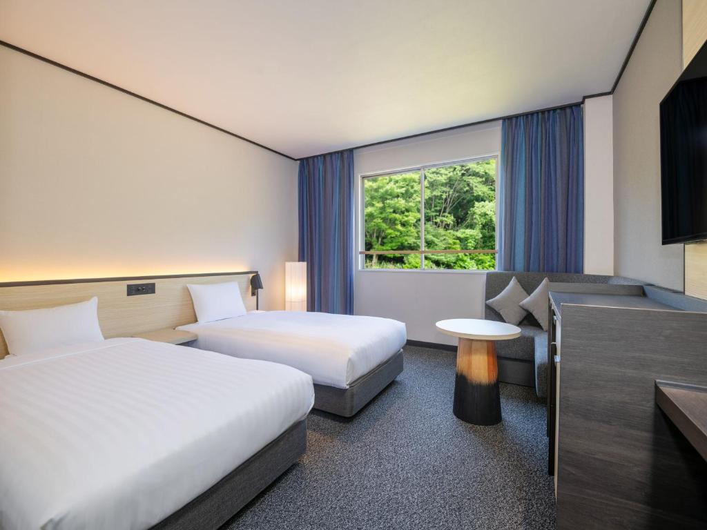 Postel nebo postele na pokoji v ubytování Kirishima Kokusai Hotel